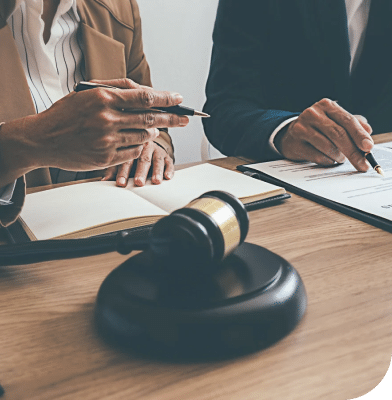 professionals dressed in suits sitting at desk with open books and gavel